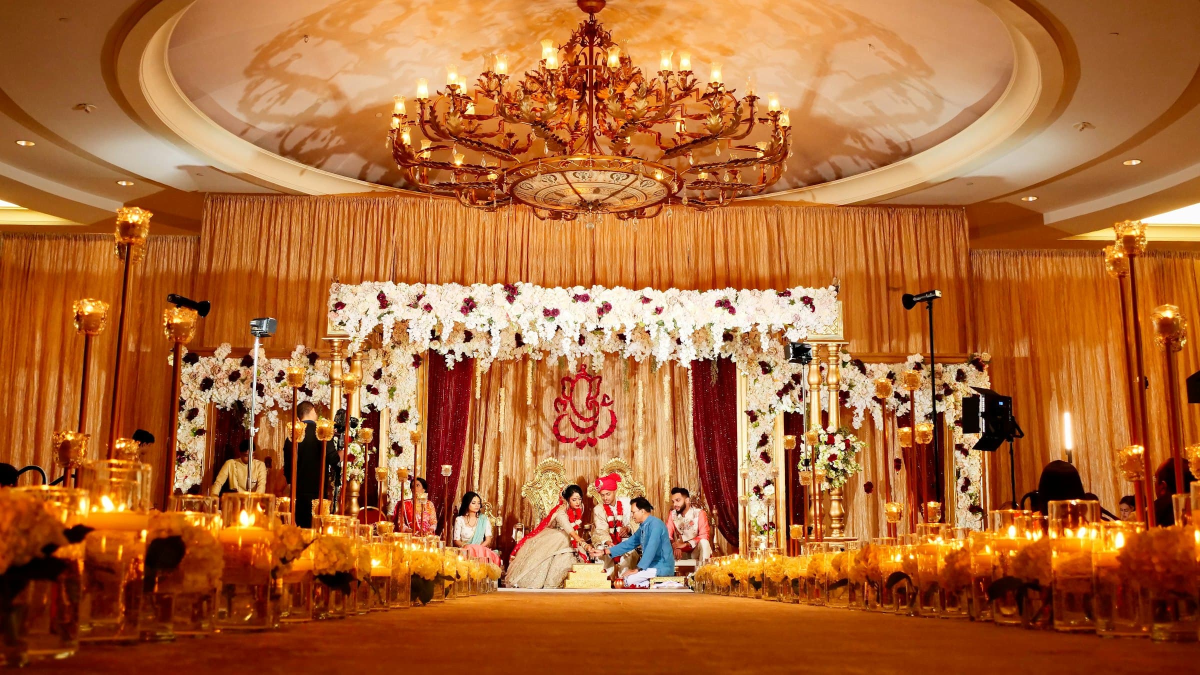 A candlelit mandap framed by white florals at an Indian wedding ceremony