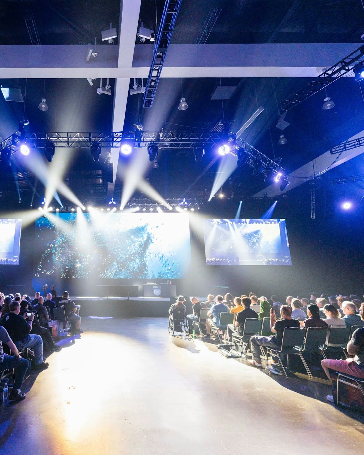 An audience seated in front of a lit stage