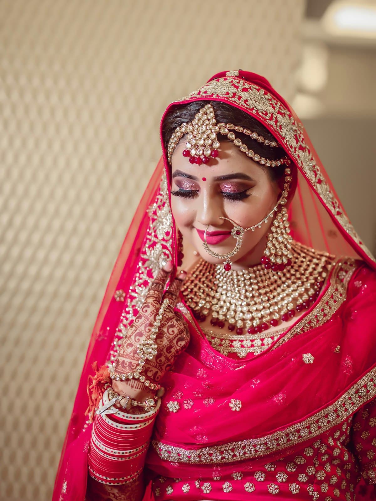A bride wearing layered gold jewellery and henna