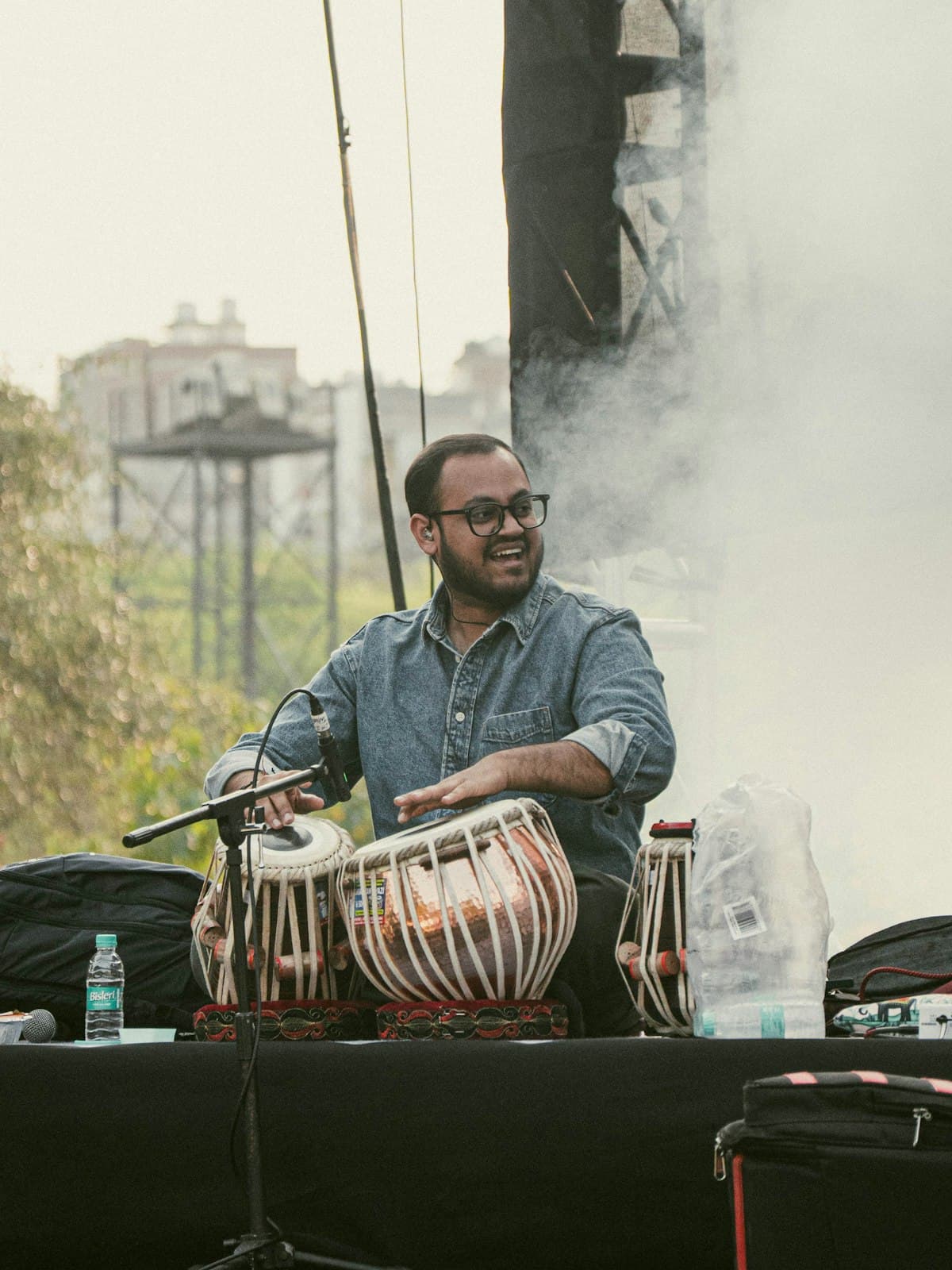 A musician playing tabla on a low stage